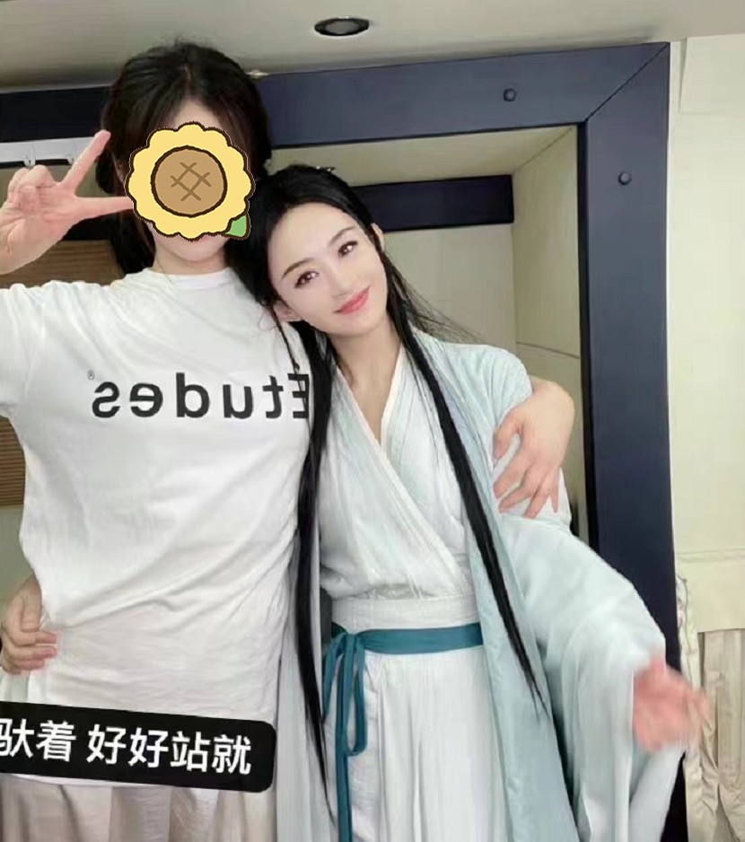 赵丽颖叉腰搂抱工作人员合影，身穿剧中造型，照片磨皮过度变网红