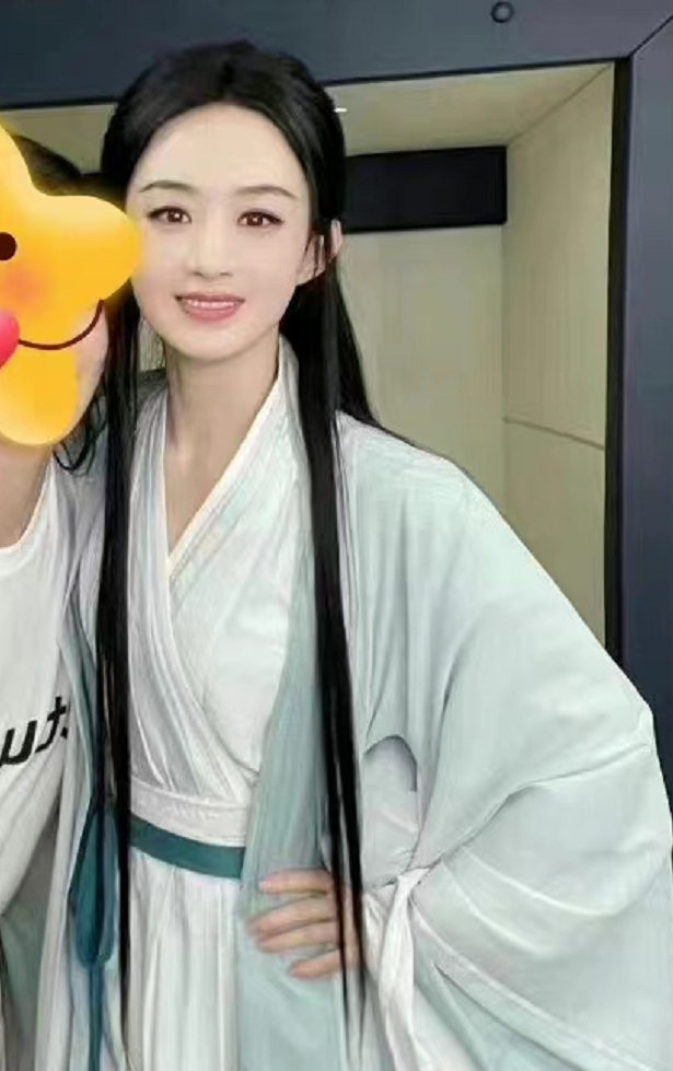 赵丽颖叉腰搂抱工作人员合影，身穿剧中造型，照片磨皮过度变网红