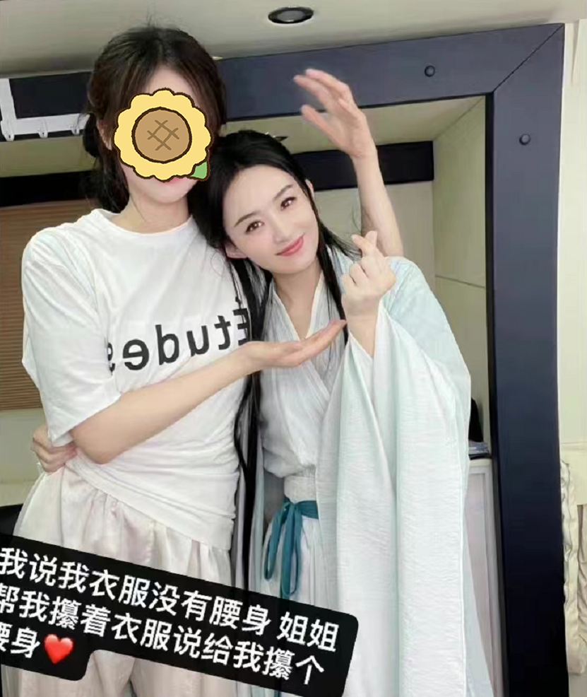 赵丽颖叉腰搂抱工作人员合影，身穿剧中造型，照片磨皮过度变网红