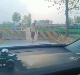 ​蚂蚁撼树？山东一男子开车遇限宽无法通行，妻子竟欲挪动千斤路障